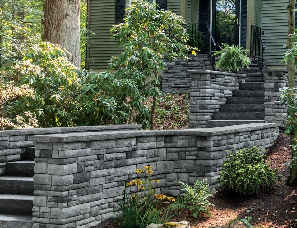 Retaining wall and steps in front of house near garden beds | retaining wall contractors | Creative Pavers
